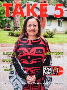 Woman with black and red top with indigenous design.