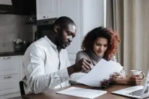 Two people sitting at a desk and looking through documents