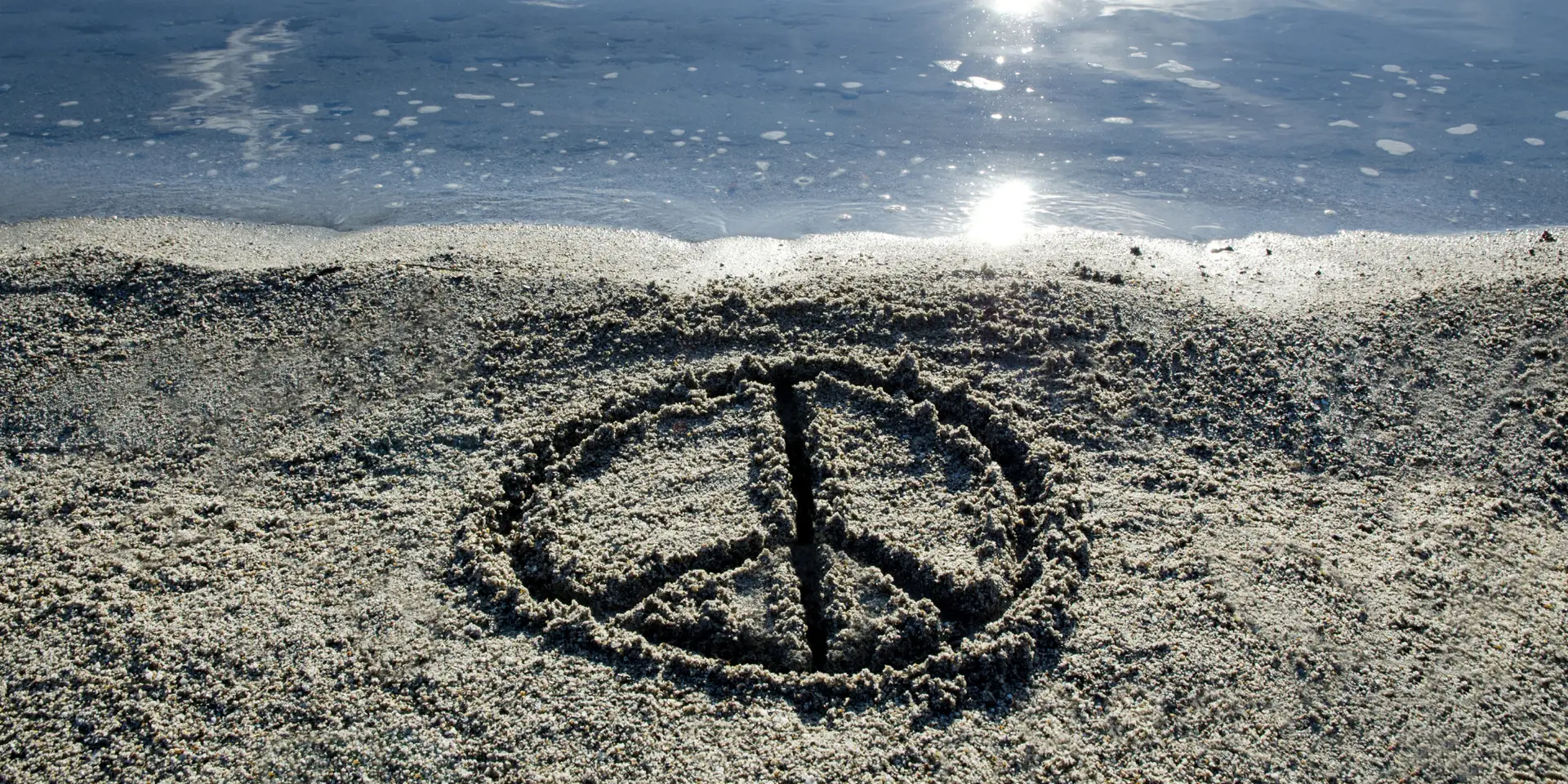 Finding Peace - peace sign in sand with water in background