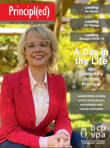 Principled 2022 March cover with Lucinda Wolters, elementary school principal - blond woman wearing red blazer and hands clasped