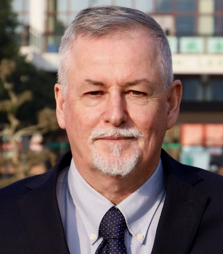 Michael Brown, Principal, Wuhan Maple Leaf High School - older white man in suit and tie with beard and mustache.