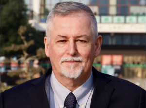 Michael Brown, Principal, Wuhan Maple Leaf High School - older white man in suit and tie with beard and mustache.