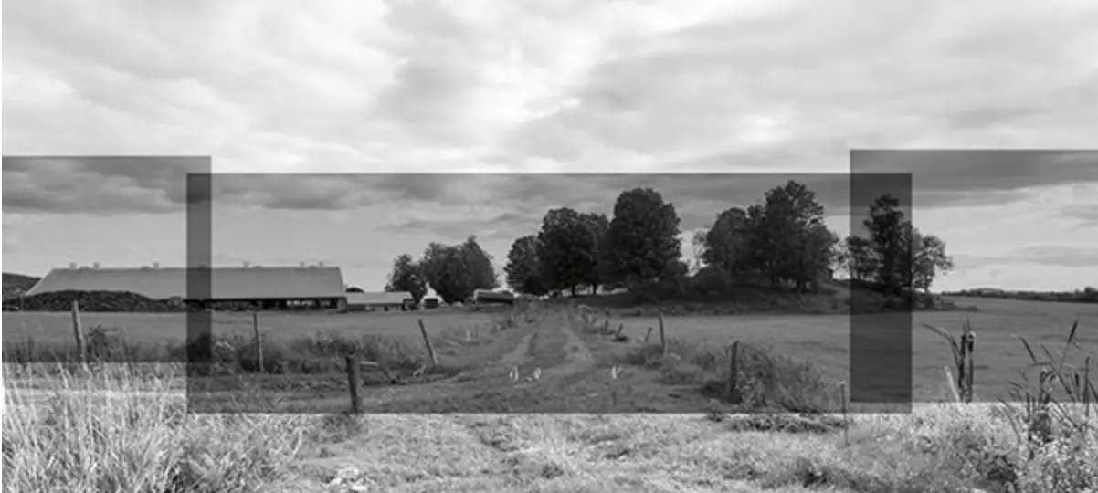 Flat rural area with fencing, gravel road and trees in distance, the picture having grey overlays to frame parts. Credit Michel Huneault.
