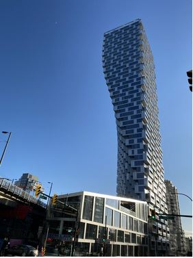 View of 52 story highrise with lower building in neo-futurism style:"Vancouver House" by BIG Bjarke Ingels