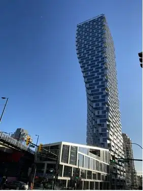 View of 52 story highrise with lower building in neo-futurism style:"Vancouver House" by BIG Bjarke Ingels