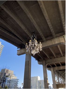 Looking up at structural underside of large concrete bridge with "Spinning Chandelier" assemblage by Rodney Graham