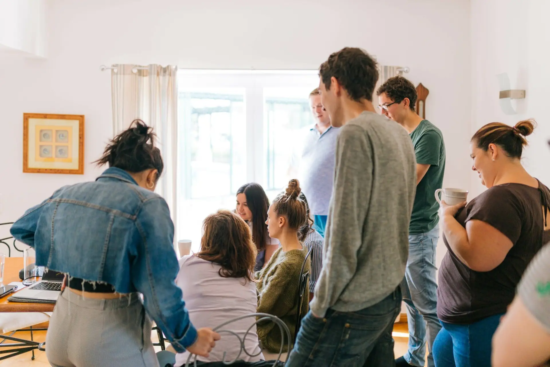 Five people standing near four people sitting near desk. Image by Fox.