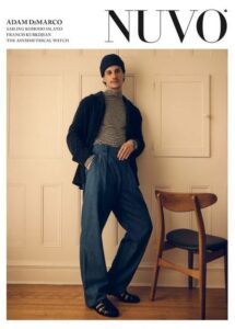 NUVO Issue 104, Spring 2025 cover featuring a stylish young man leaning against a neutral coloured wall with a chair beside him