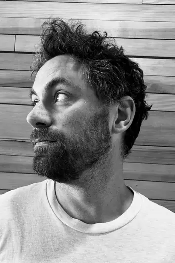 Black and white head and shoulder portrait of Stephen Smysnuik, looking off the left.