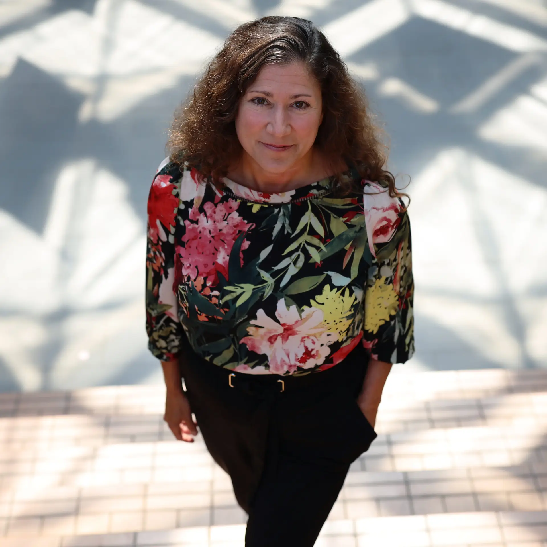 Fiona Bramble, standing portrait photographed from the top with an abstracted background of light and shadow