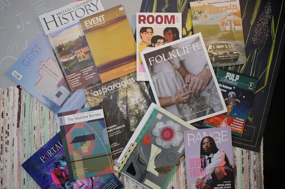 Covers of various MagsBC member magazines participating in the Non-traditional Newsstand project, spread randomly on a surface: Geist, British Columbia History, Event, Room, sub-Terrain, Asparagus, Folklife, Pulp. Portal, The Malahat Review, Teh Capilano Review, Range