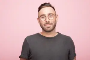 Colour portrait of Glenn Anderson against a plain, rose-coloured background.