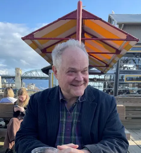 Colour portrait of Richard Mackie, publisher of The British Columbia Review, in an outdoor setting, smiling