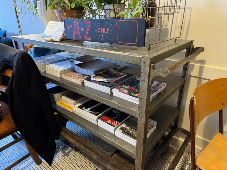 A display of a variety of BC magazines on the middle and lower shelves of, what looks like, an old, rusty metal tea or book trolley.